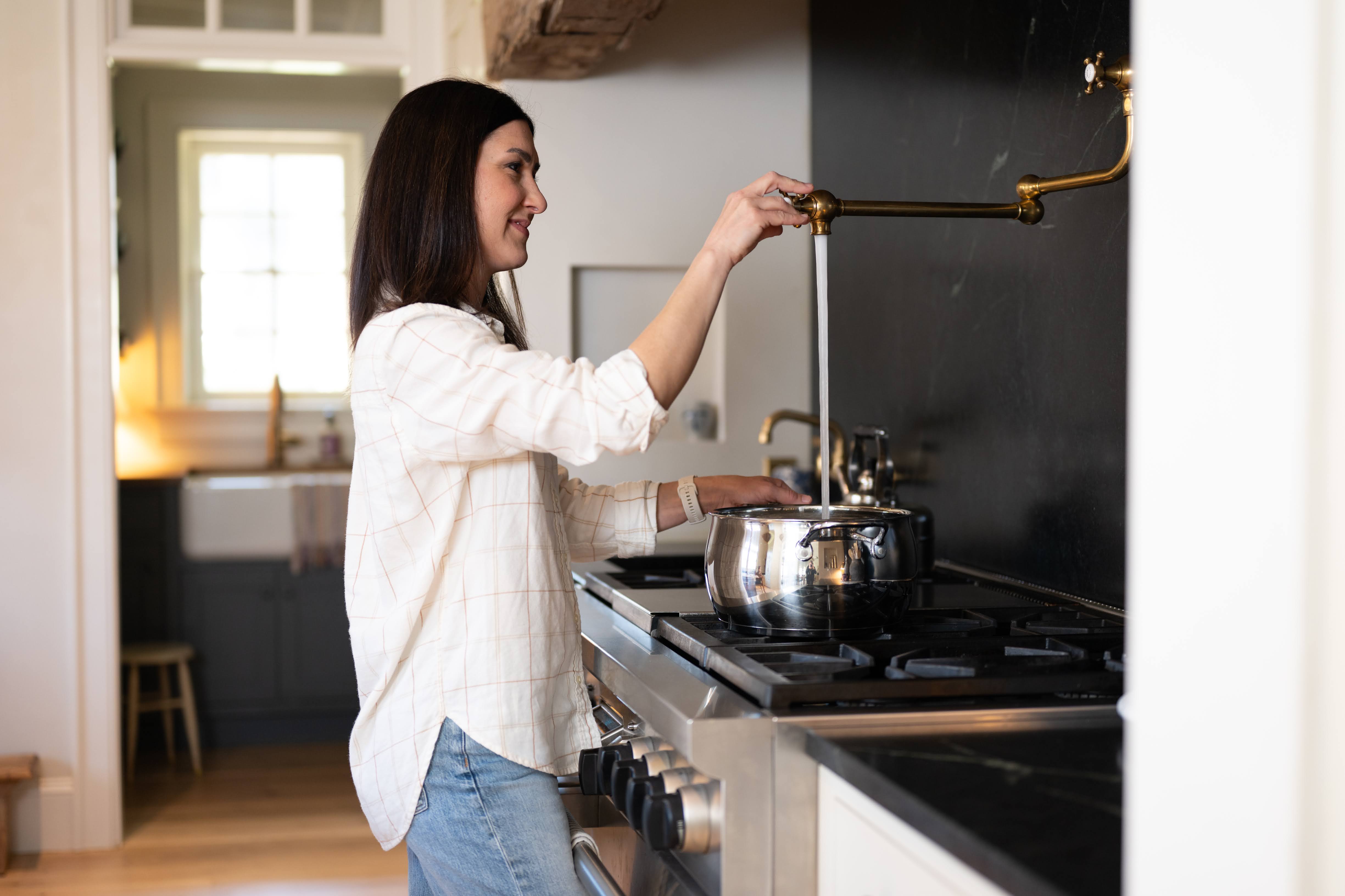 woman filling pot with water