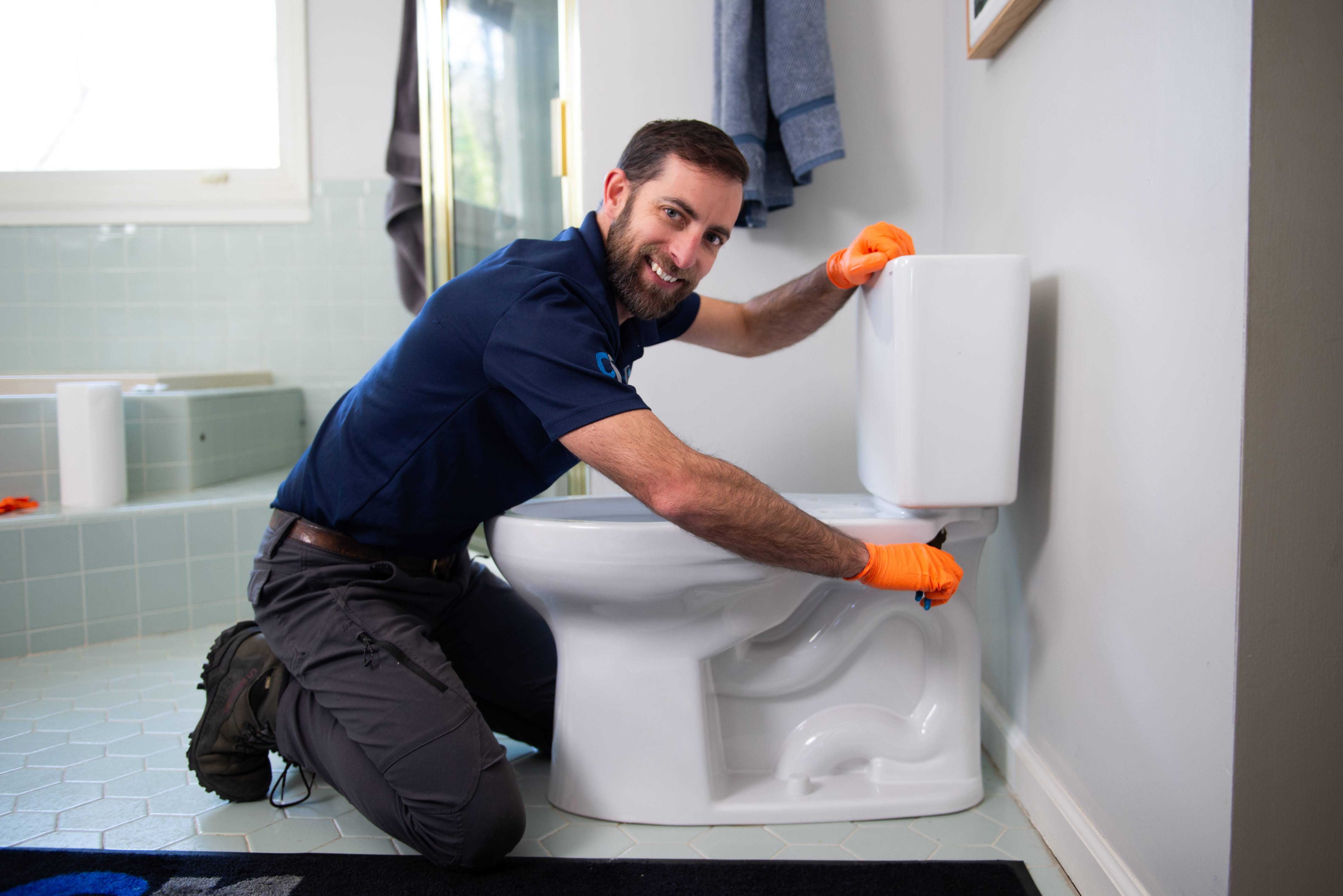 Plumber fixing a toilet