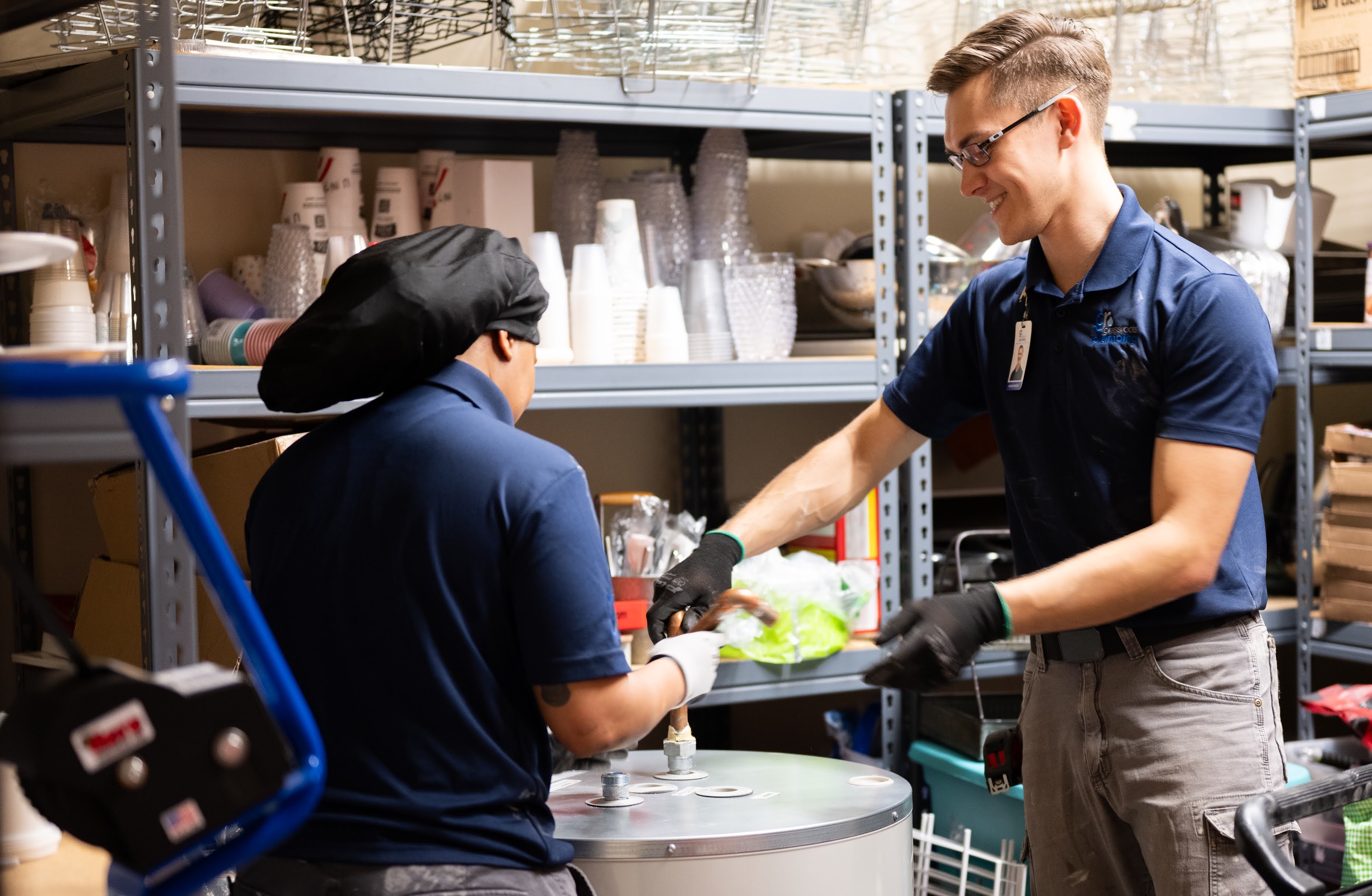 Two plumbers working on water heater