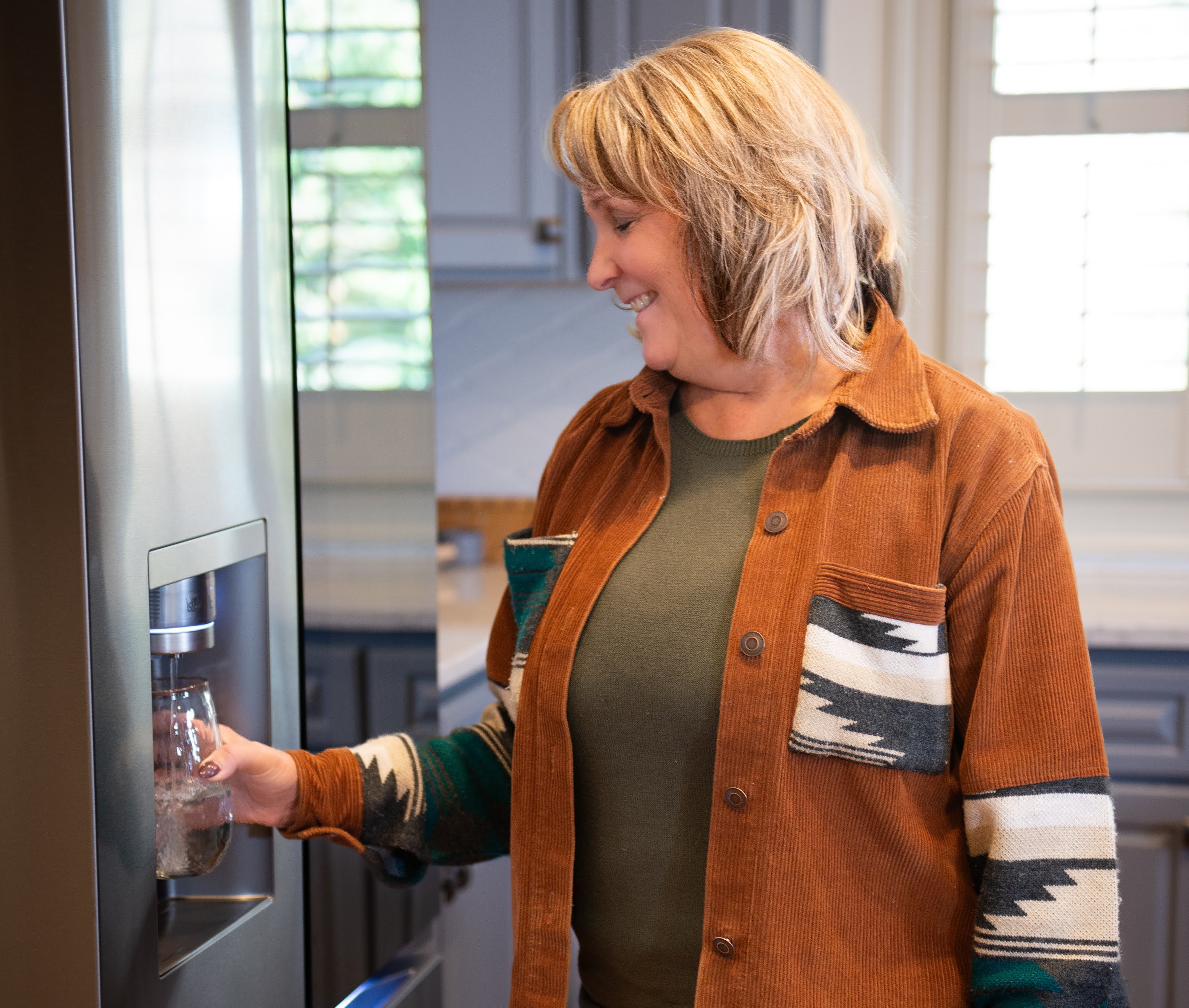Woman in kitcehn filling water glass